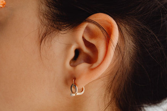 Woman wearing simple gold stud earrings