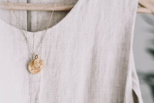 flat-lay of gold vermeil demi-fine jewelry set on neutral linen background