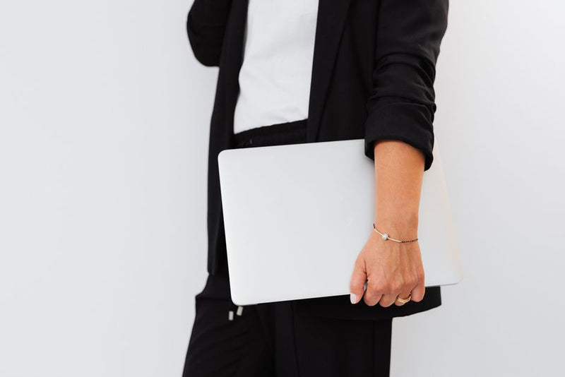 Professional woman wearing minimal gold jewelry in a natural light setting