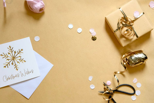 Gold necklace and earrings beside holiday greenery, a Christmas jewelry gift in Canada